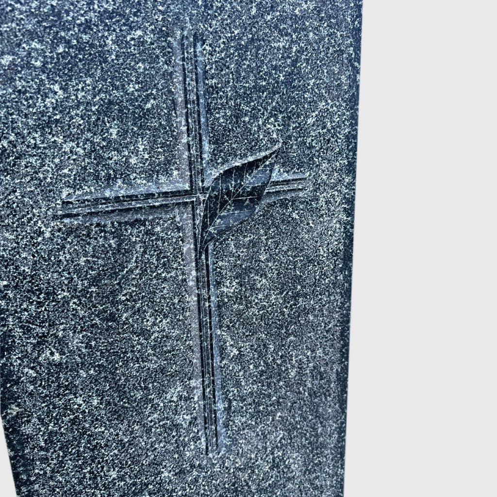 Grabstein aus Hassan Green Granit mit erhaben gearbeitetem Kreuz und gestockter Oberfläche – würdevoller Naturstein in Stelenform