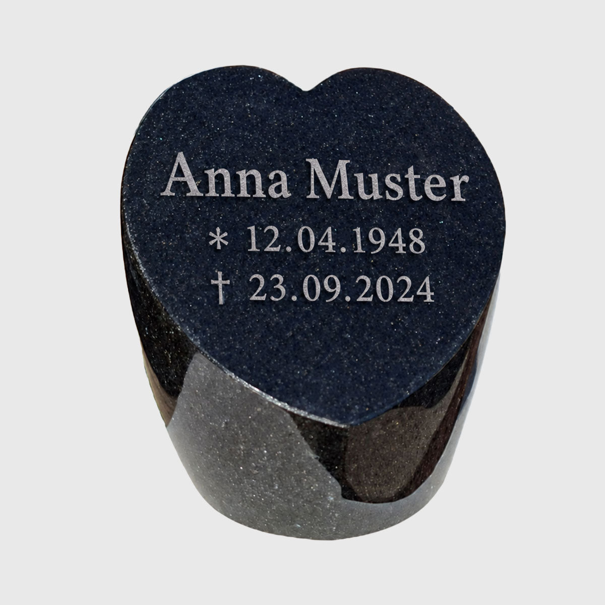 Gedenkstein in Herzform mit der Musterinschrift Anna Muster und fiktiven Geburts- und Sterbedaten