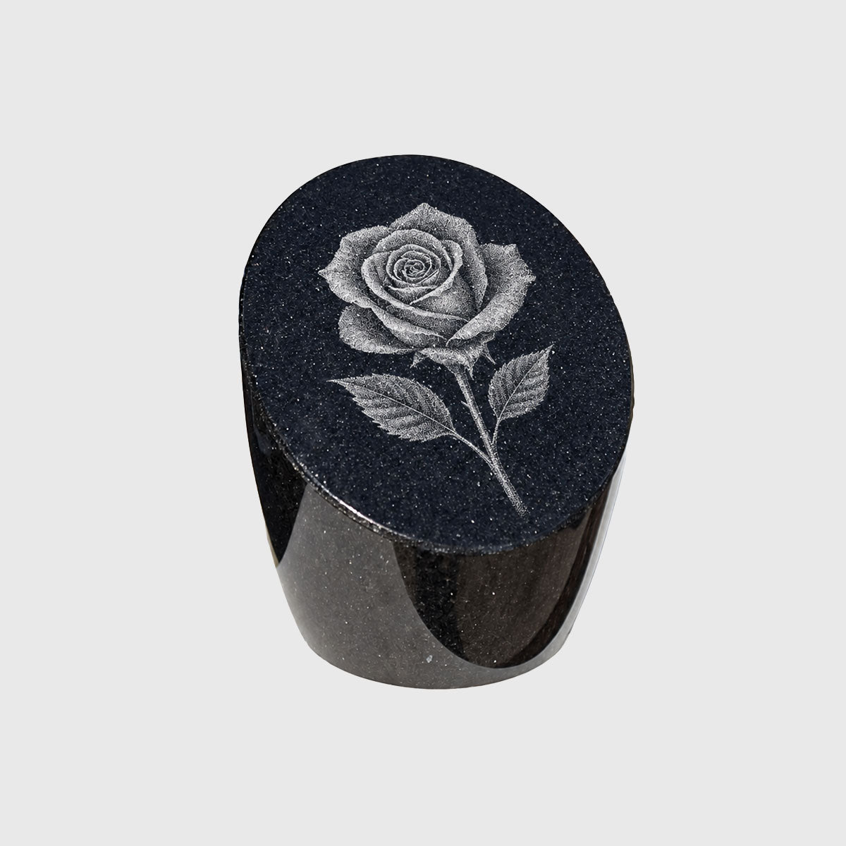 Ovaler Gedenkstein aus schwarzem Granit mit einer Rose als Ritzbild