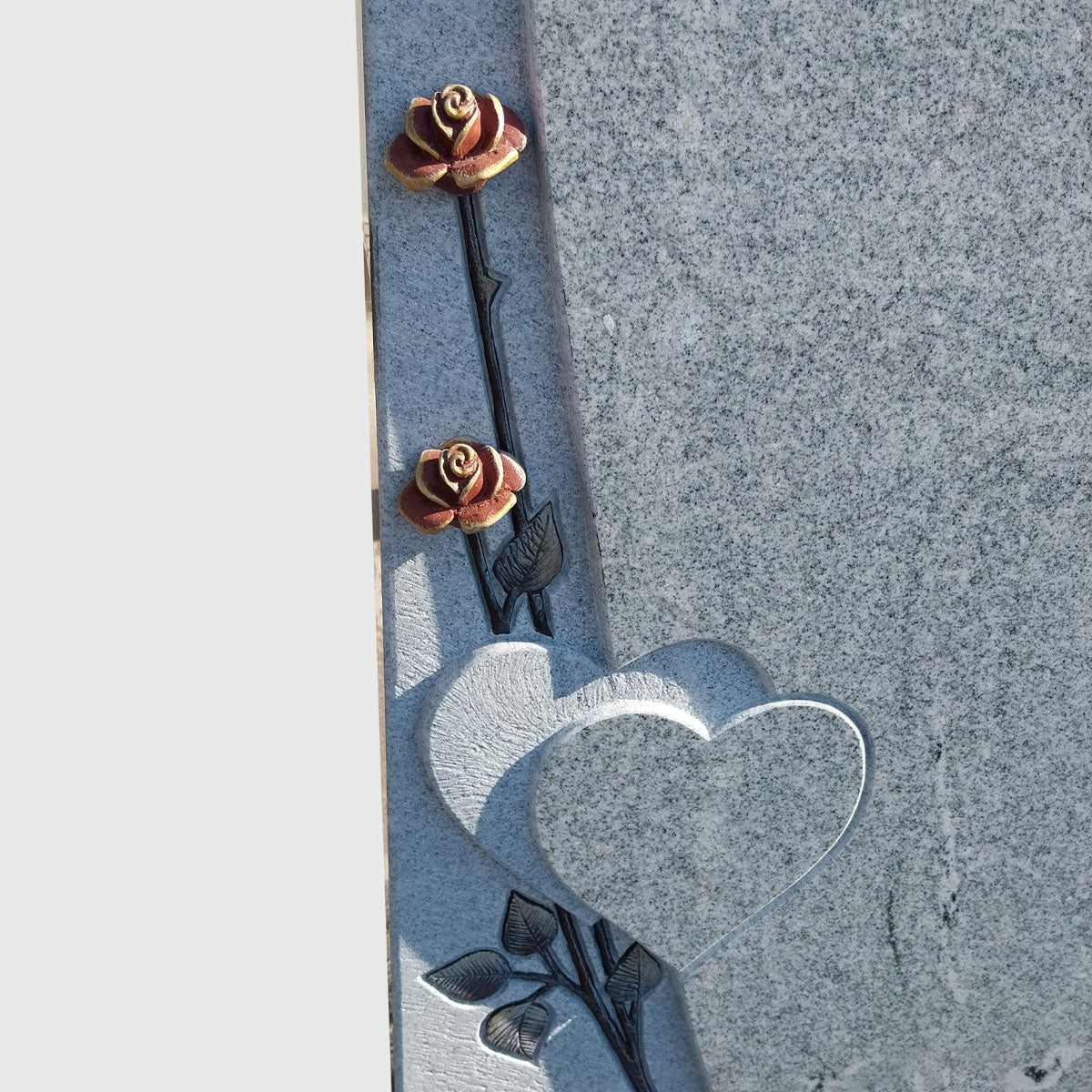 Stele aus Viscount White Granit mit Herz- und Rosenmotiv.